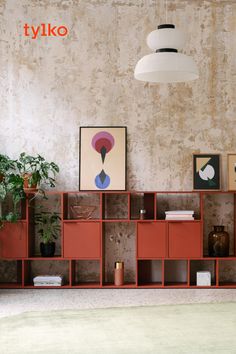 a living room filled with lots of furniture next to a wall covered in pictures and plants