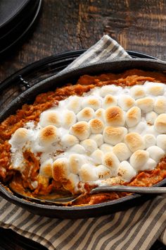 a casserole dish with marshmallows and sauce