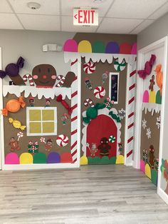 an office decorated for christmas with gingerbread houses and candy canes on the doors