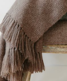 a brown blanket sitting on top of a wooden chair