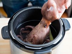 a person is stirring some food in a slow cooker