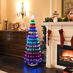 a brightly lit christmas tree sitting in front of a fireplace