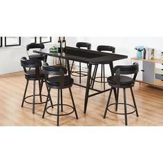 a dining table with six chairs and a bar stool in front of it on a hard wood floor