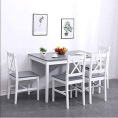 a dining table with four chairs and a bowl of fruit on the table next to it