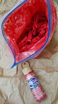 an open plastic bag with letters in it next to a bottle of glue and scissors