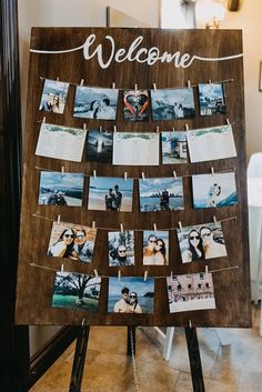 a welcome sign with photos hanging on clothes pins and magnets attached to the board