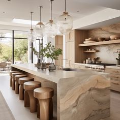 a large kitchen with marble counter tops and stools in front of the bar area