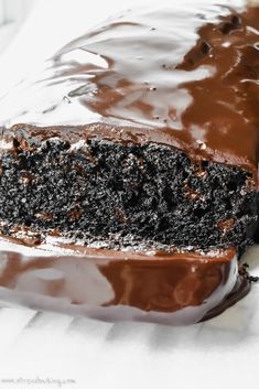 a close up of a piece of cake with chocolate frosting on it's surface