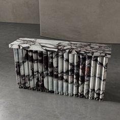 a marble bench sitting on top of a floor next to a cement wall and concrete block