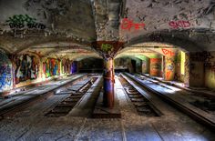 an abandoned train station with graffiti all over the walls