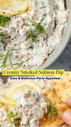 a bowl filled with creamy smoked salmon dip next to crackers and lemon wedges