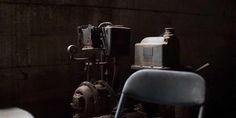 an old chair sitting next to a water pump in a room with concrete walls and exposed pipes