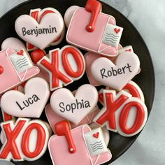 decorated cookies in the shape of letters and numbers for valentine's day are displayed on a plate