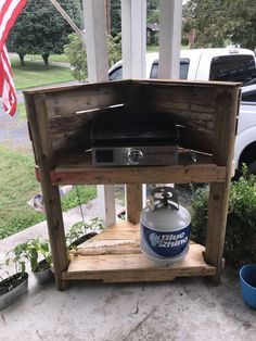 an outdoor grill made out of pallet wood and a gas bottle on it's stand