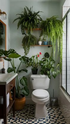 a white toilet sitting in a bathroom next to a green plant filled wall above it