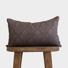 a brown pillow sitting on top of a wooden stool