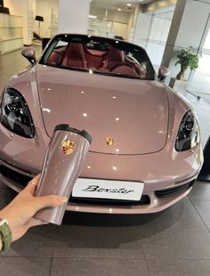 a pink sports car is on display in a showroom