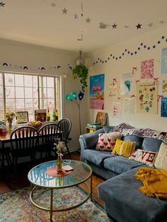 a living room filled with furniture next to a table and chairs in front of a window