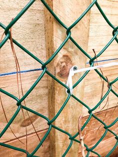 a piece of paper stuck to the side of a wooden fence post with wires attached