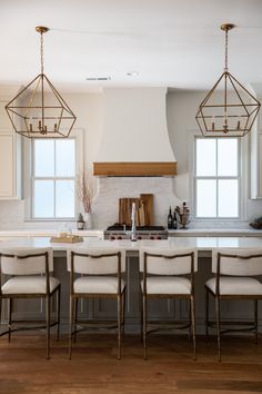 a kitchen island with four chairs in front of it and a stove top oven on the other side