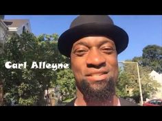 a man with a hat on standing in front of some trees and buildings that says carl allegne