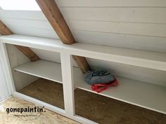 an attic with white painted walls and open shelving