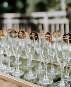 many wine glasses are lined up on a tray