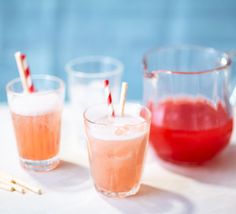 two glasses filled with drinks sitting on top of a table