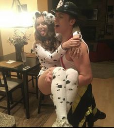 two people dressed up as dalmatian dogs and one is hugging the other's face