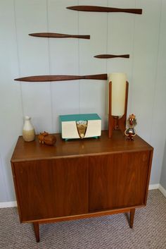 a wooden cabinet sitting on top of a carpeted floor next to a white wall