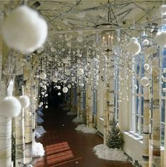 the inside of a building with lots of white balls hanging from it's ceiling