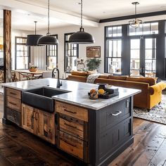 a kitchen with an island, sink and couches in it