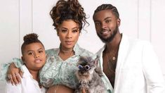 the couple and their daughter are posing for a photo with their dog, who is dressed in