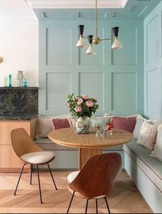 a kitchen with a table and chairs next to a bench in front of a window