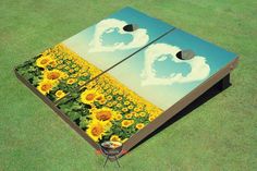 sunflowers and clouds painted on the side of a cornhole tosser game