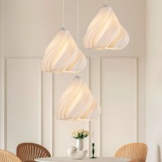 a white table with four chairs and three lights