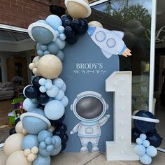 an astronaut balloon arch with the number one on it