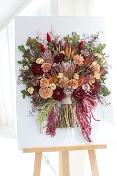 a bouquet of flowers sitting on top of a easel