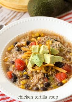 a white bowl filled with chicken, black beans and avocado