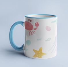 a blue and white coffee mug with crabfish, starfish, and seaweed on it