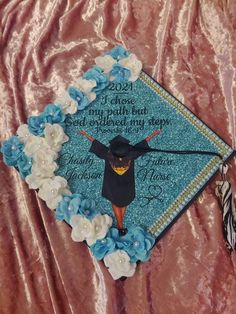 a blue graduation cap with an image of a woman in the center and flowers around it