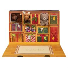 an open box with teddy bears and presents in it's display case on a wooden table