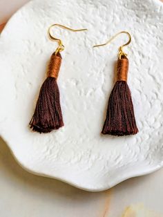 Get ready to elevate your style with our "Nova Mini" Brown 2 Color Tassel Earrings! The beautiful gold-plated design adds a touch of elegance, while the tassel accents bring a fun and trendy vibe. Stand out from the crowd with these must-have earrings that are perfect for any occasion. Diy Tassel Earrings, Earrings Diy, Tassel Jewelry, Polymer Clay Necklace, Hypoallergenic Jewelry, Clay Necklace, Stand Out From The Crowd, Celestial Jewelry, Resin Necklace