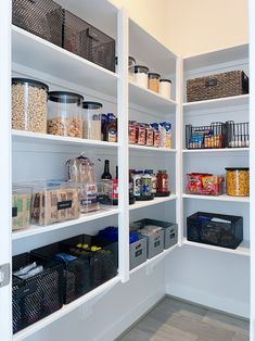 an organized pantry with white shelving and lots of food in baskets on the shelves