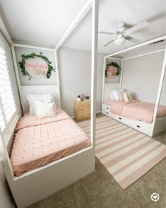 two twin beds in a bedroom with pink and white decor on the walls, along with a striped rug