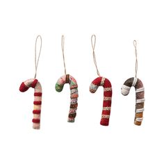 three christmas ornaments hanging from strings on a white background, each decorated in different colors