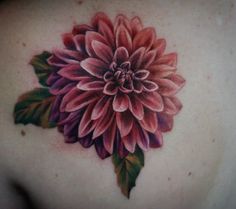 a woman's back with a flower tattoo on it