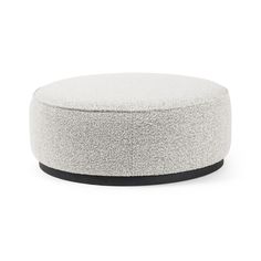 a white round ottoman with black trim on the top and bottom, in front of a white background