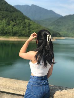 a woman is looking out over the water