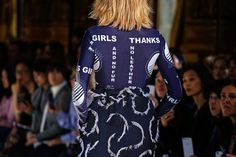 the back of a woman's dress with writing on it at a fashion show